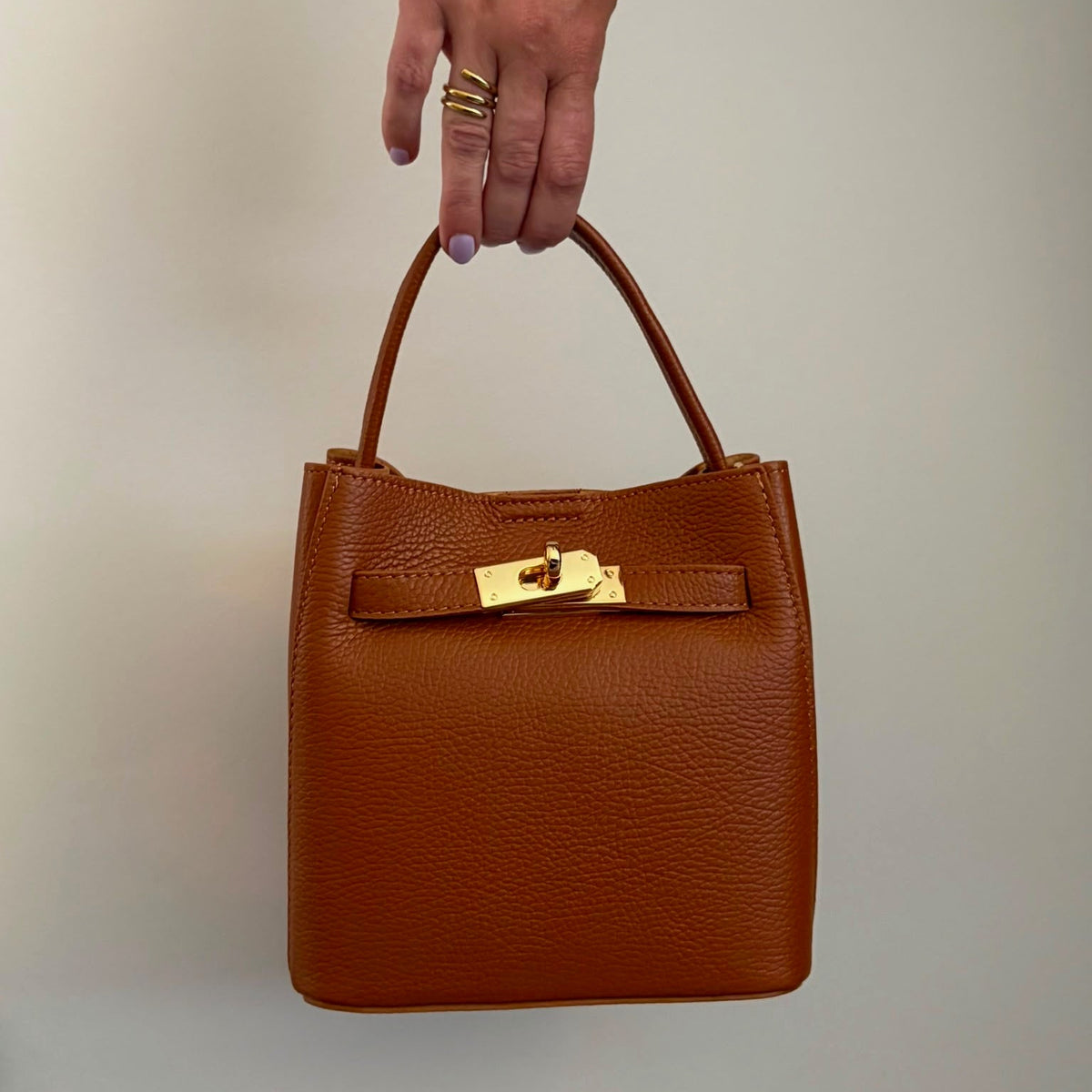 Cognac kleurige leren handtas met kort hengels en gouden sluiting